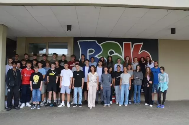 Klasse 9a und 9b stehen mit MdB Frau Schwarzelühr-Sutter auf dem Schulhof zusammen